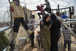 Syrian refugees leave a food distribution administered by the World Food Program and UNICEF at the Zaatari refugee camp in Jordan, April 7, 2013.  Roughly 100,000 Syrian refugees live in the camp, and more arrive each day through official and unofficial border crossings between Syria and Jordan as the civil war in Syria enters its third year.   The United Nations estimates that the number of Syrian refugees is currently over one million.   (Credit: Lynsey Addario, for The New York Times)