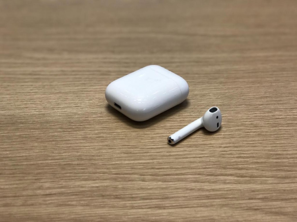 A display of the AirPods, showing the holding/charging case and one side of the headphones. Photo Credit: Sean Lomba