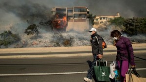 Family carries remaining belongings after escaping fire. Photo Credit: ABC 7 News