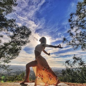 Krystal Aranyani practicing yoga in nature. Credit to Koi Fresco.