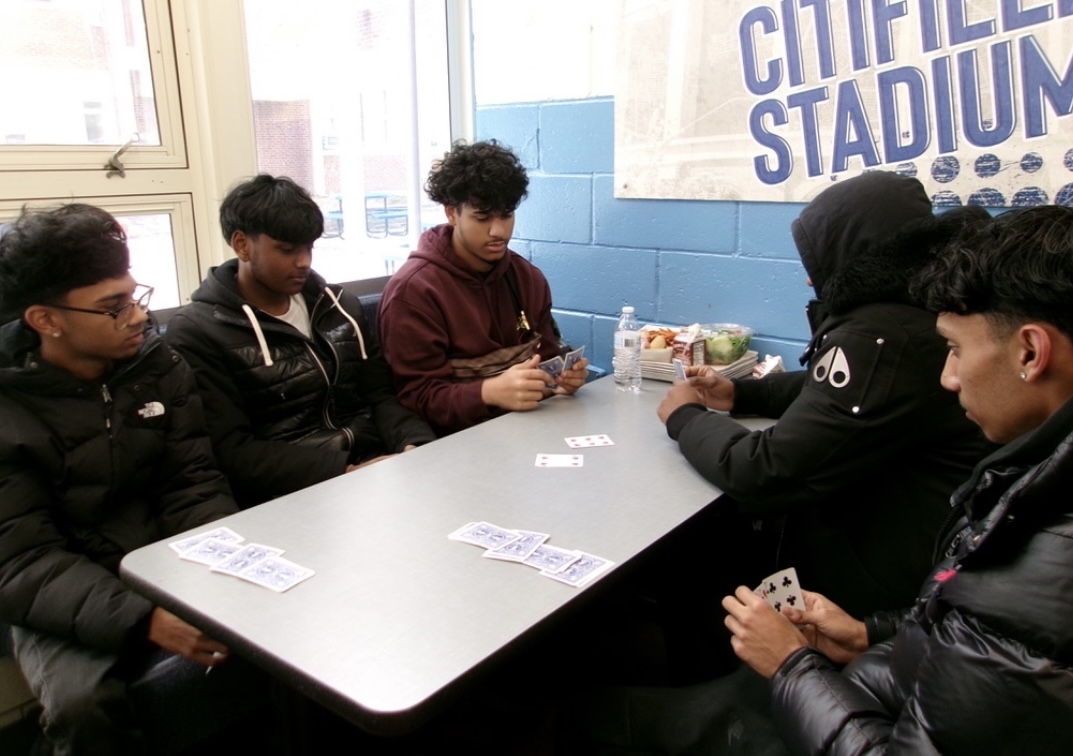 Students playing cards to pass the time during lunch.