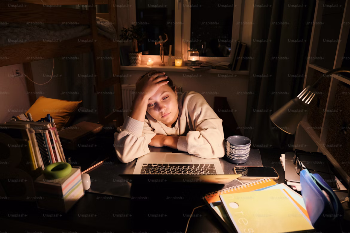 A student stressed out late at night and in front of their laptop.