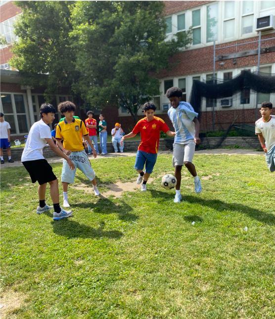 Students enjoying a game of soccer in the courtyard during half time.